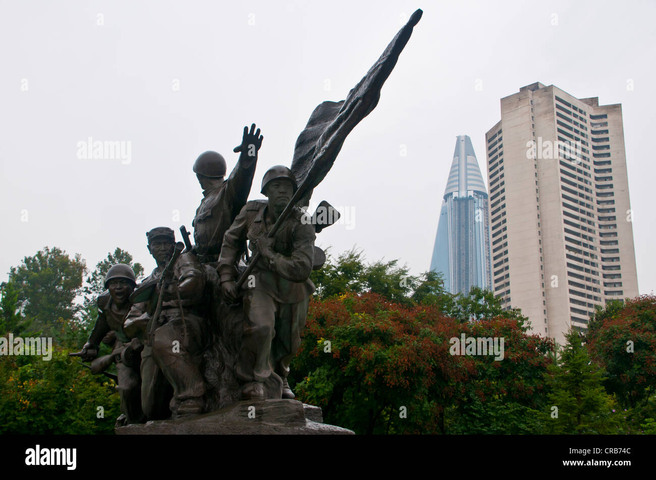 Monumento alla patria guerra di liberazione, nella parte anteriore del incompiuto Ryugyong Hotel, il più grande hotel di Pyongyang Foto Stock