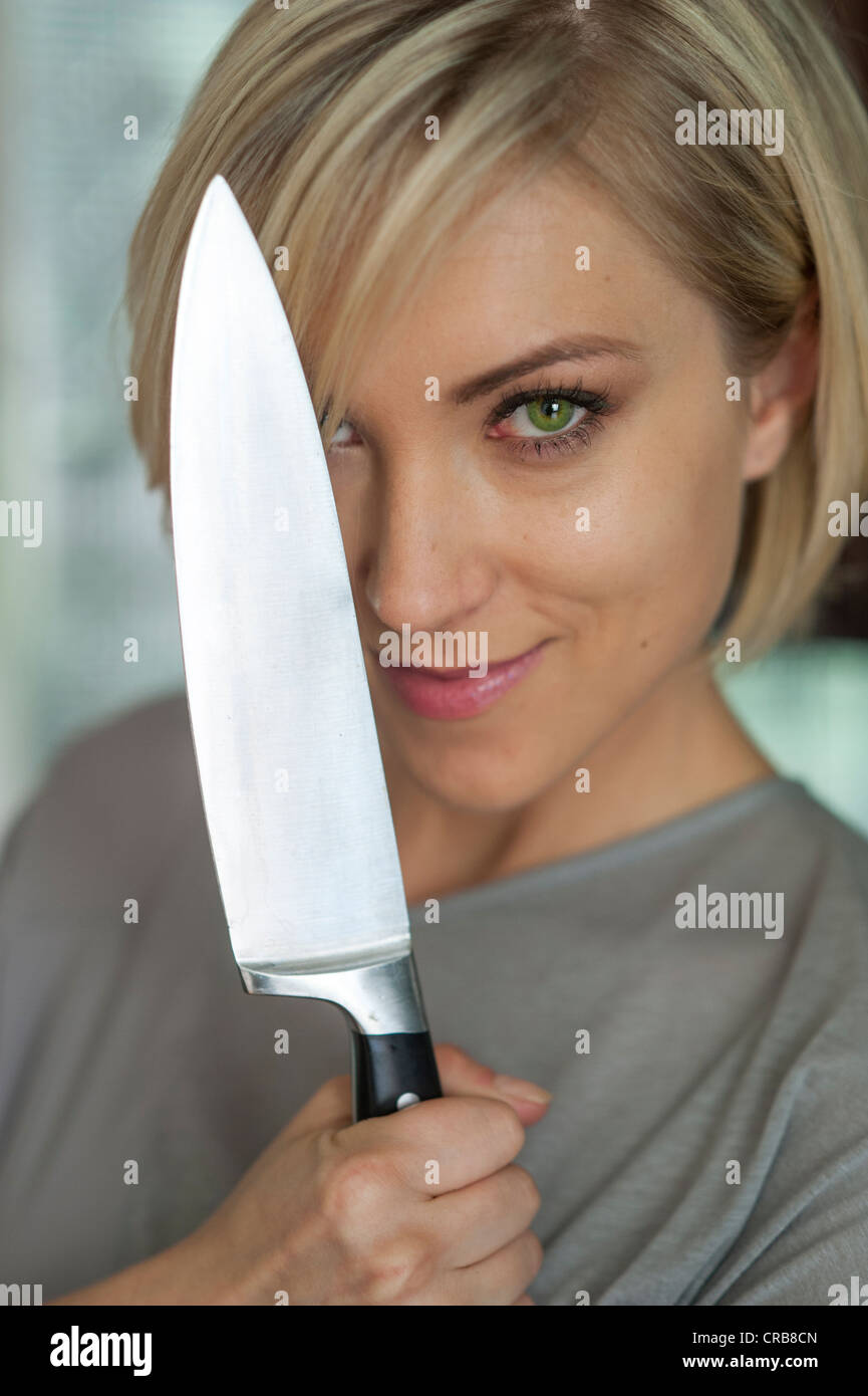 Donna con coltello da cucina Foto Stock