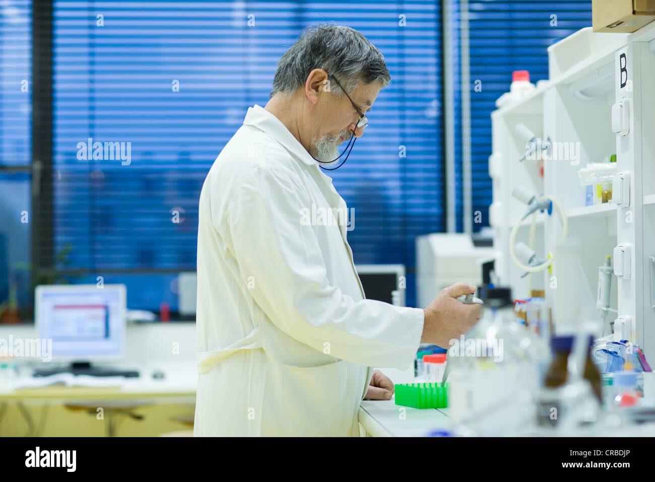 Maschio senior researcher di effettuare attività di ricerca scientifica in laboratorio utilizzando un gascromatografo (SHALLOW DOF; dai toni di colore immagine) Foto Stock