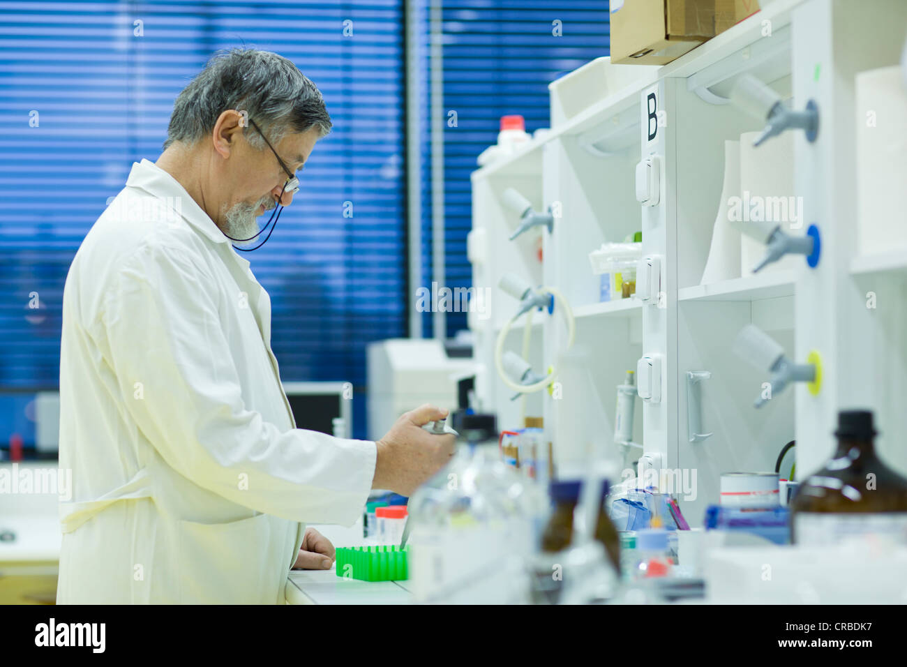 Maschio senior researcher di effettuare attività di ricerca scientifica in laboratorio utilizzando un gascromatografo (SHALLOW DOF; dai toni di colore immagine) Foto Stock