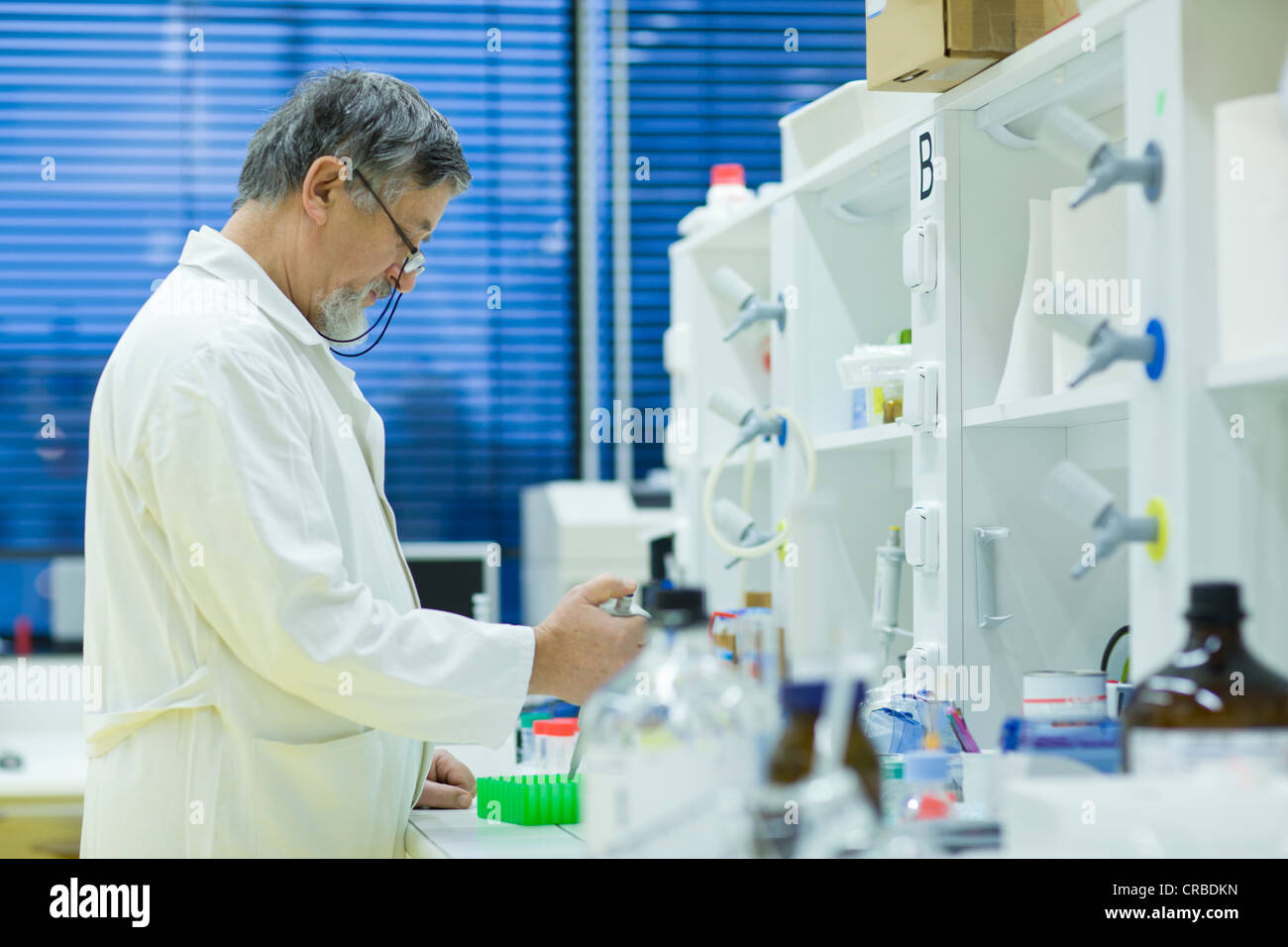 Maschio senior researcher di effettuare attività di ricerca scientifica in laboratorio utilizzando un gascromatografo (SHALLOW DOF; dai toni di colore immagine) Foto Stock