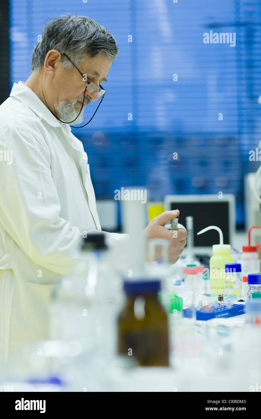 Maschio senior researcher di effettuare attività di ricerca scientifica in laboratorio utilizzando un gascromatografo (SHALLOW DOF; dai toni di colore immagine) Foto Stock