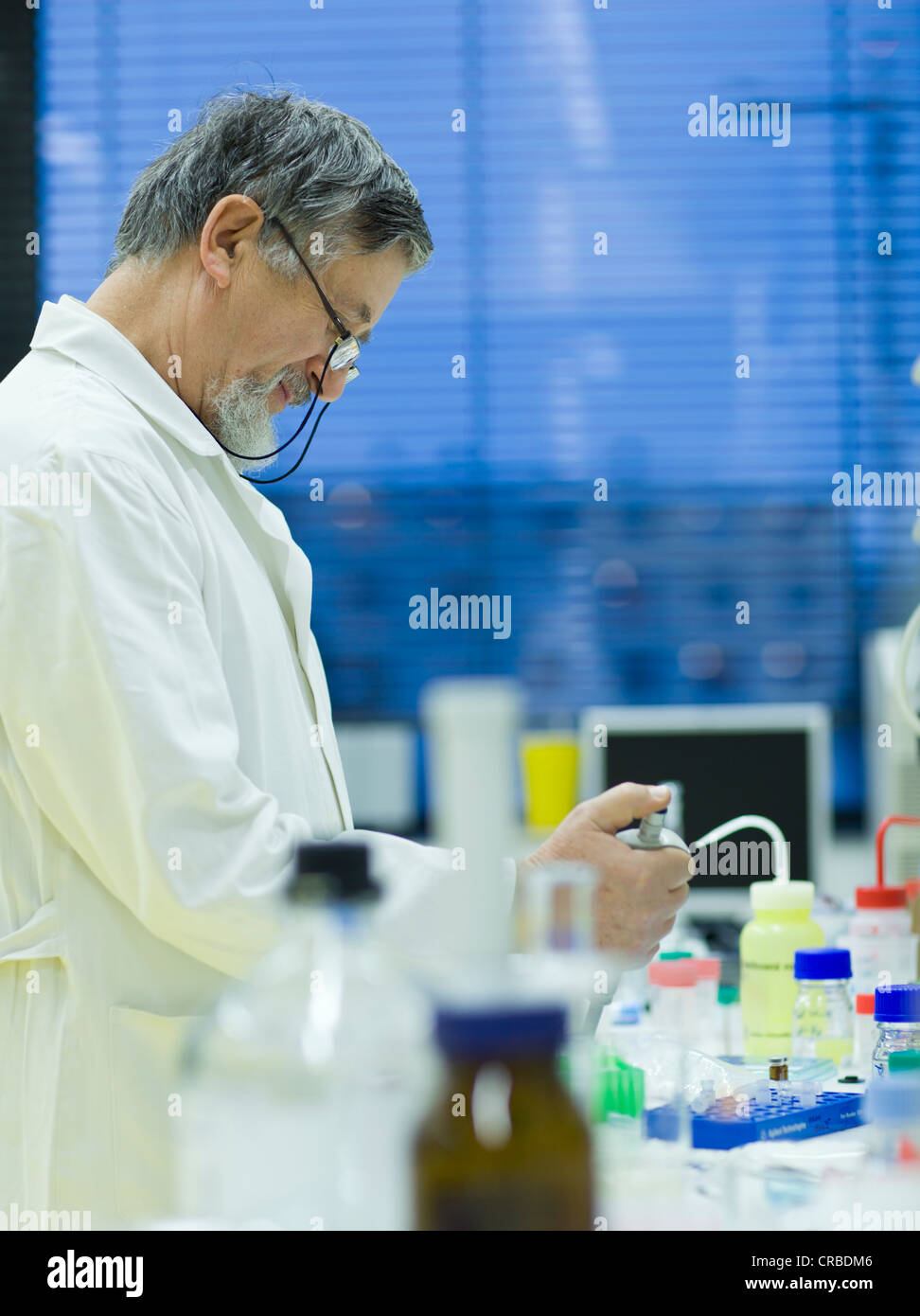 Maschio senior researcher di effettuare attività di ricerca scientifica in laboratorio utilizzando un gascromatografo (SHALLOW DOF; dai toni di colore immagine) Foto Stock