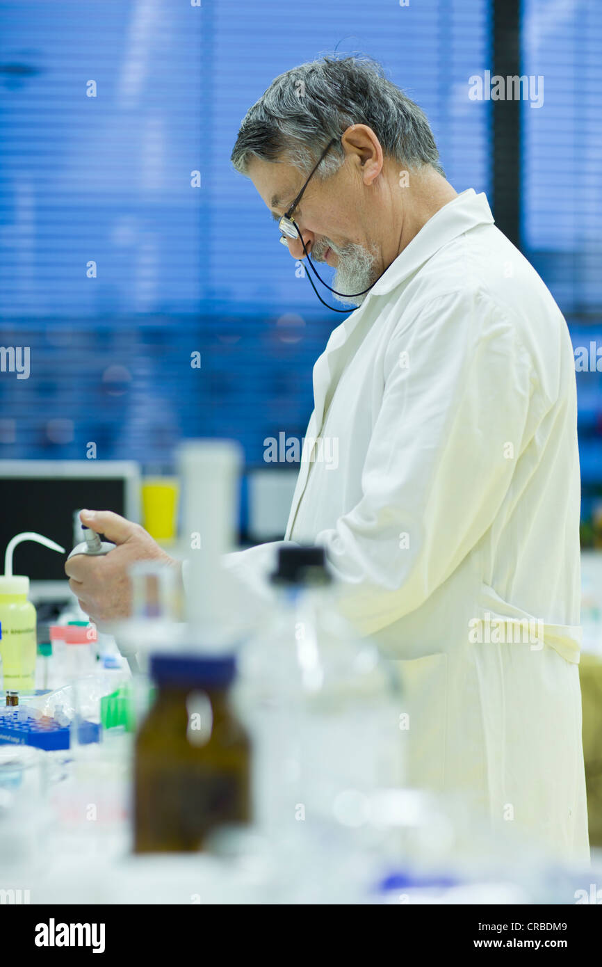 Maschio senior researcher di effettuare attività di ricerca scientifica in laboratorio utilizzando un gascromatografo (SHALLOW DOF; dai toni di colore immagine) Foto Stock