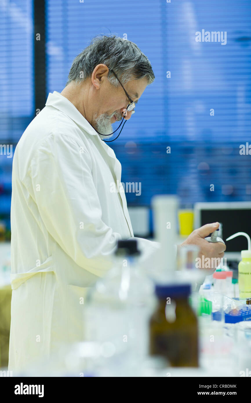Maschio senior researcher di effettuare attività di ricerca scientifica in laboratorio utilizzando un gascromatografo (SHALLOW DOF; dai toni di colore immagine) Foto Stock