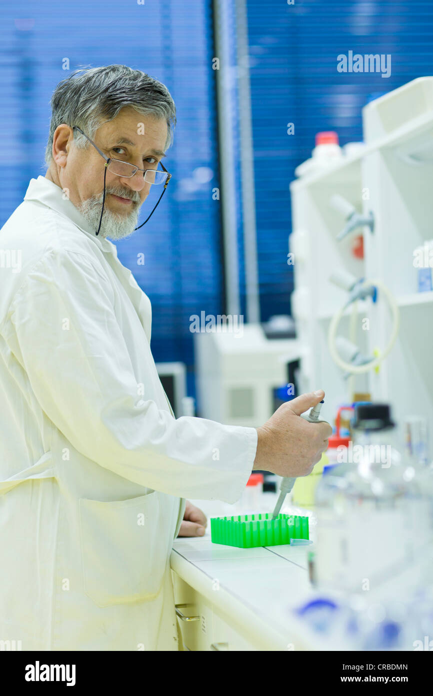 Maschio senior researcher di effettuare attività di ricerca scientifica in laboratorio utilizzando un gascromatografo (SHALLOW DOF; dai toni di colore immagine) Foto Stock