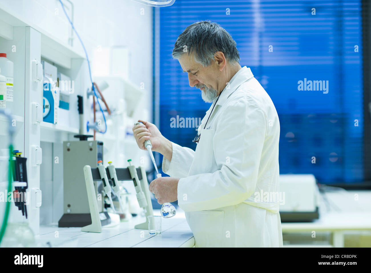 Maschio senior researcher di effettuare attività di ricerca scientifica in laboratorio utilizzando un gascromatografo (SHALLOW DOF; dai toni di colore immagine) Foto Stock