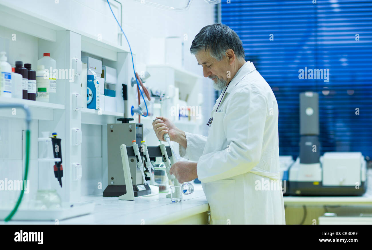 Maschio senior researcher di effettuare attività di ricerca scientifica in laboratorio utilizzando un gascromatografo (SHALLOW DOF; dai toni di colore immagine) Foto Stock