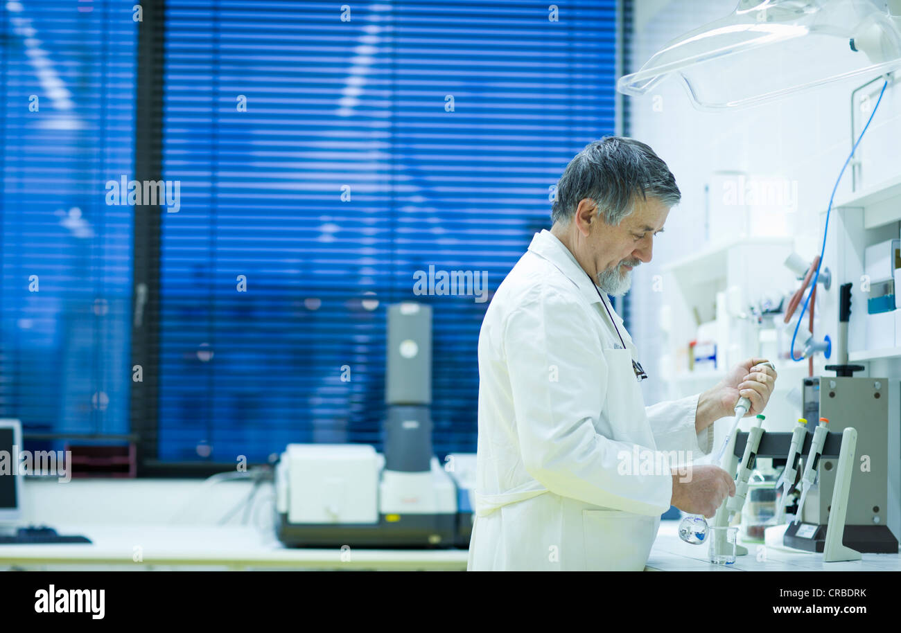 Maschio senior researcher di effettuare attività di ricerca scientifica in laboratorio utilizzando un gascromatografo (SHALLOW DOF; dai toni di colore immagine) Foto Stock