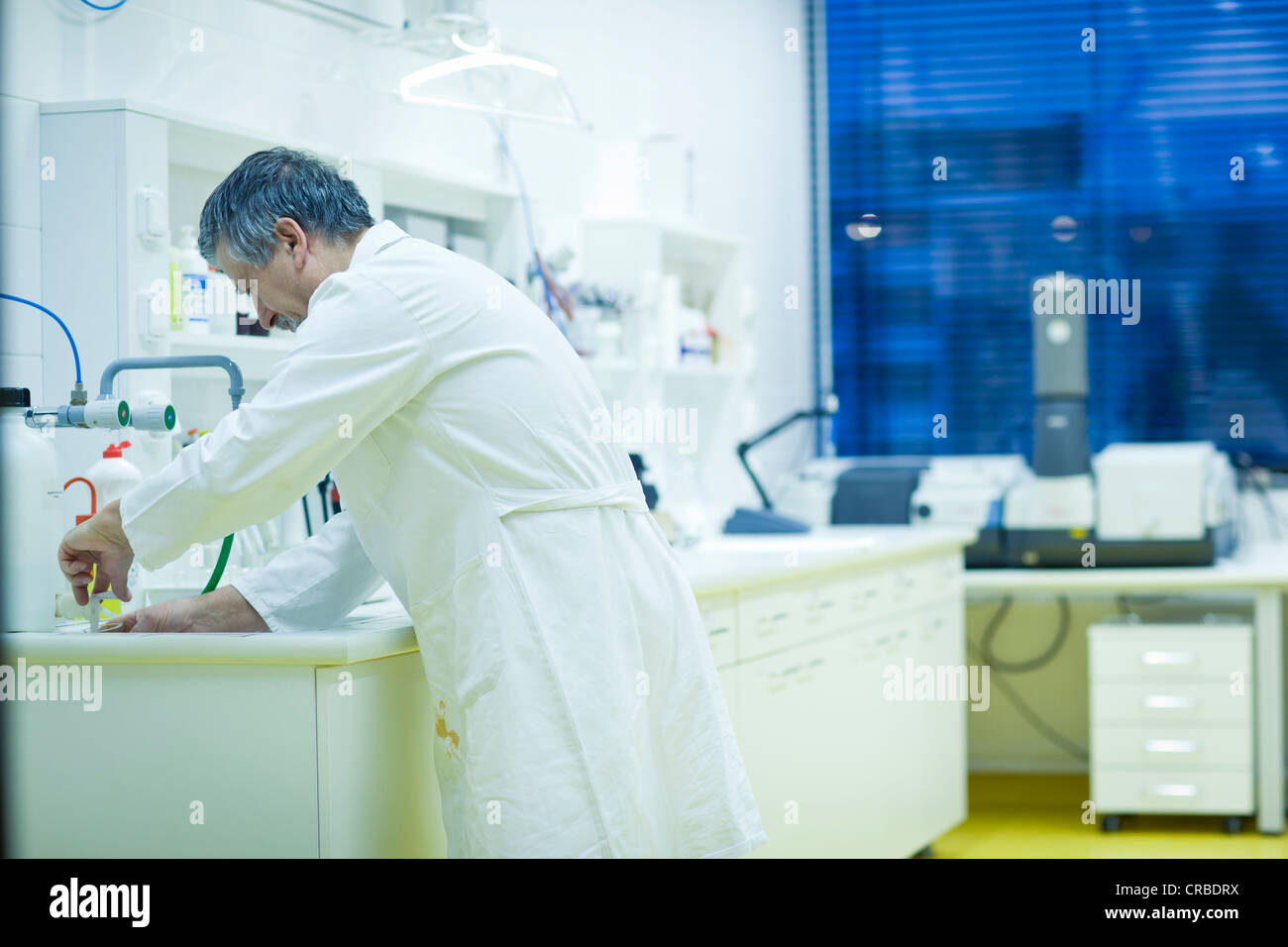 Maschio senior researcher di effettuare attività di ricerca scientifica in laboratorio utilizzando un gascromatografo (SHALLOW DOF; dai toni di colore immagine) Foto Stock