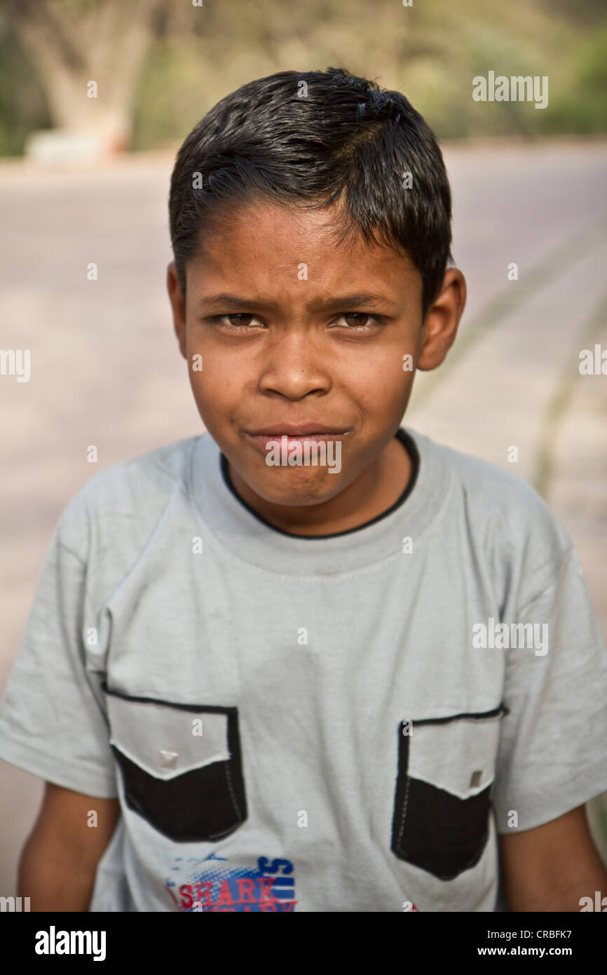 Un giovane ragazzo indiano chiede di avere la sua foto scattata mentre in un parco in Agra Foto Stock