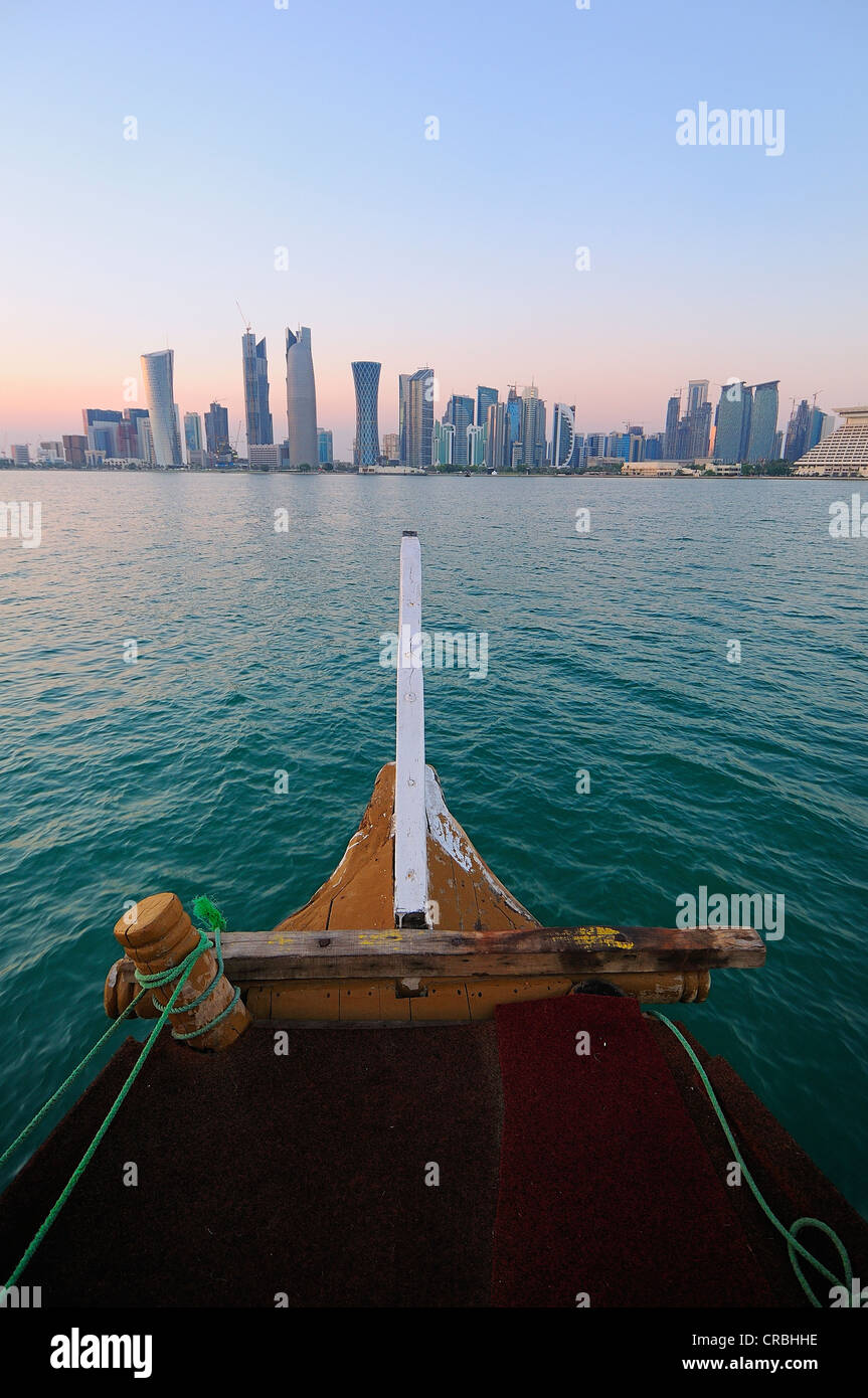 Prua di una dhow di fronte lo skyline del West Bay Area, quartiere degli affari, Doha, Qatar Foto Stock