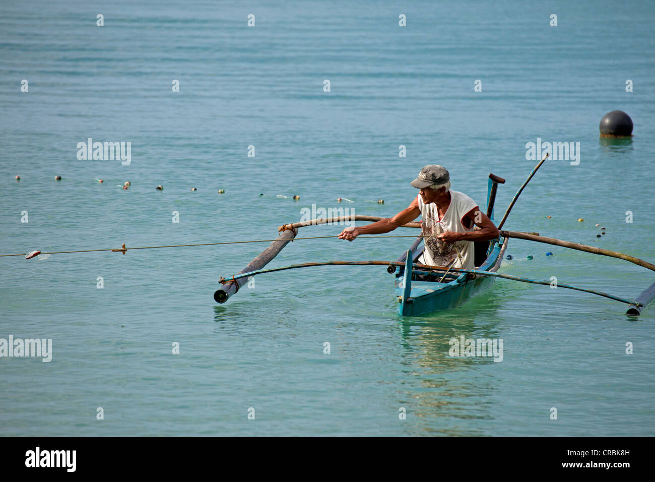 L uomo nella sua barca outrigger, Port Barton, isola di Palawan, Filippine, Asia Foto Stock