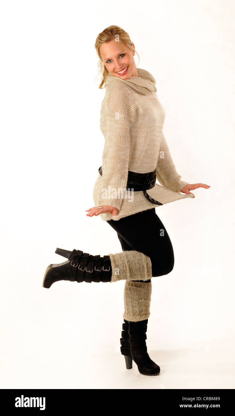 Giovane donna che indossa un maglione e stivali Foto Stock