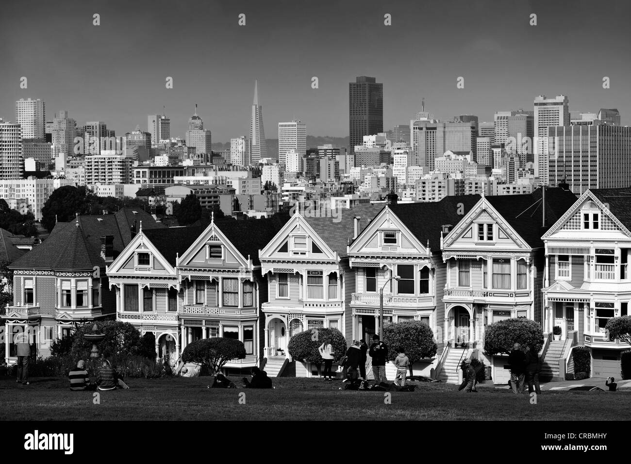 I turisti in piedi nella parte anteriore del Painted Ladies, case in stile vittoriano di fronte dello skyline di San Francisco con Transamerica Foto Stock