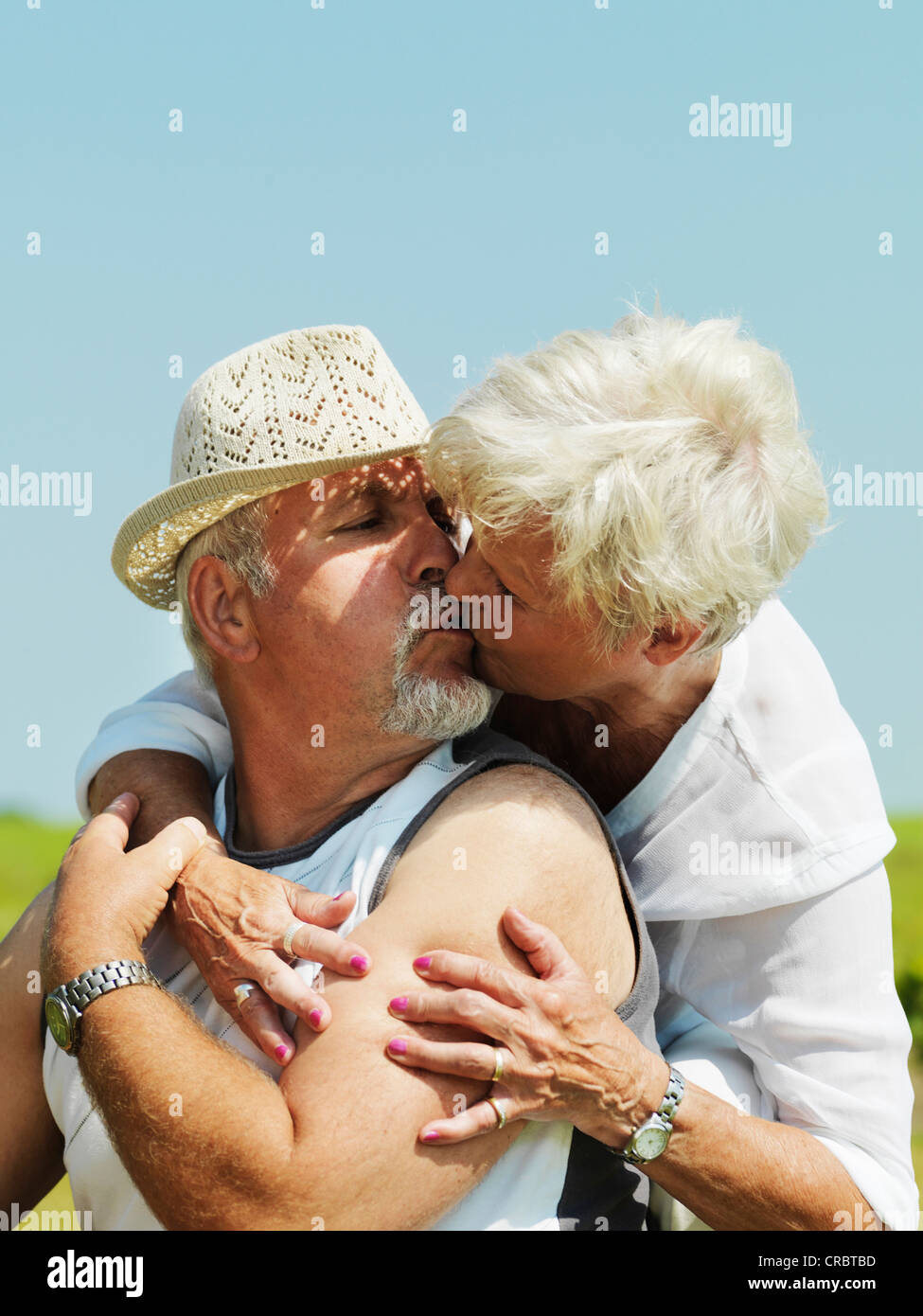 Coppia di anziani kissing all'aperto Foto Stock