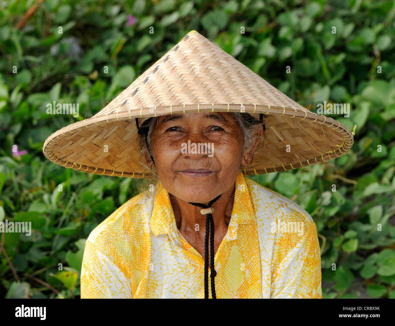 Donna indonesiana indossando un tradizionale cappello di paglia, Ubud, Bali, Indonesia, sud-est asiatico Foto Stock