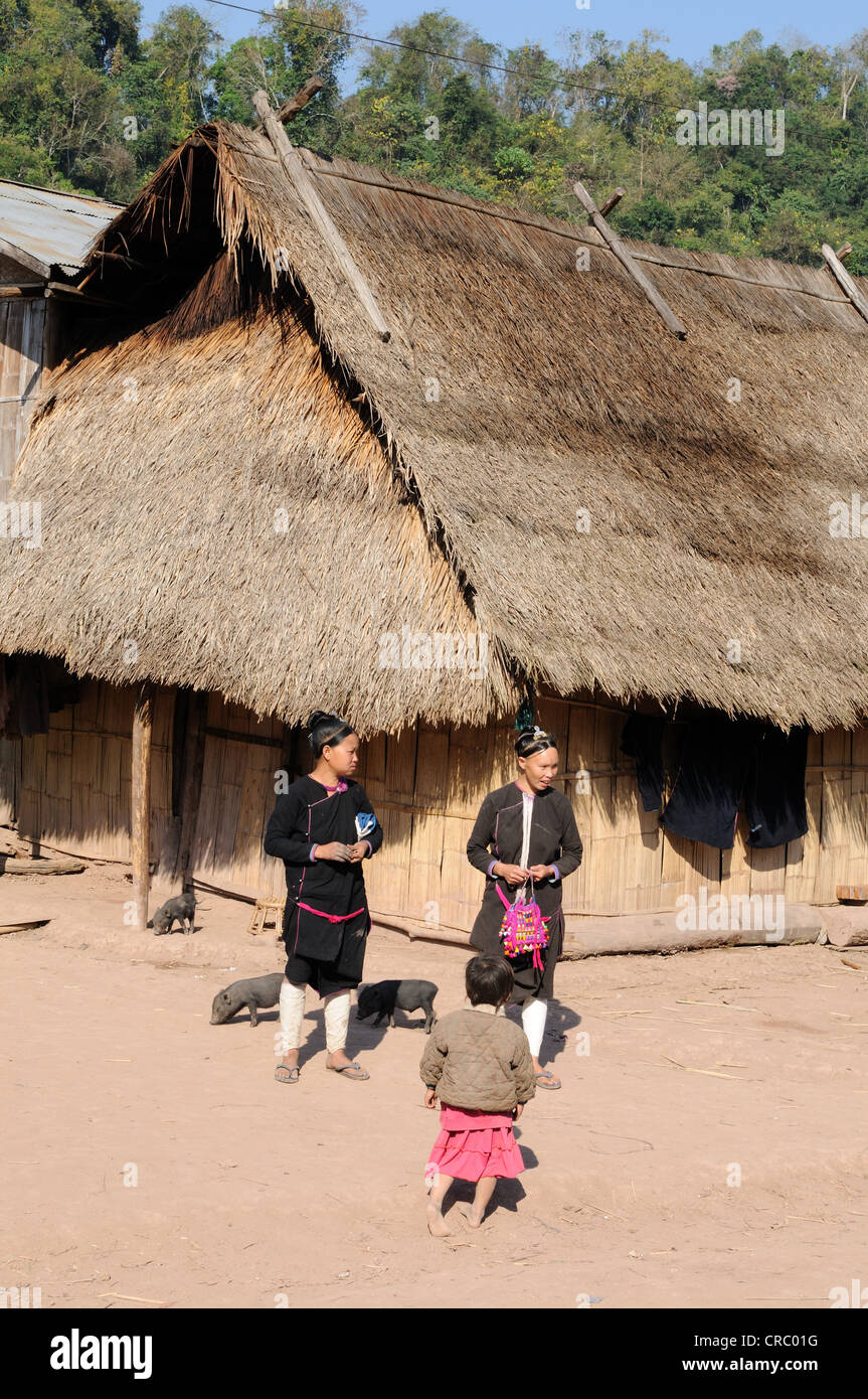 Laos Laos due donna e un bambino al di fuori del loro bambù con il tetto di paglia home divieto Namdaeng Nord del nord del Laos Foto Stock