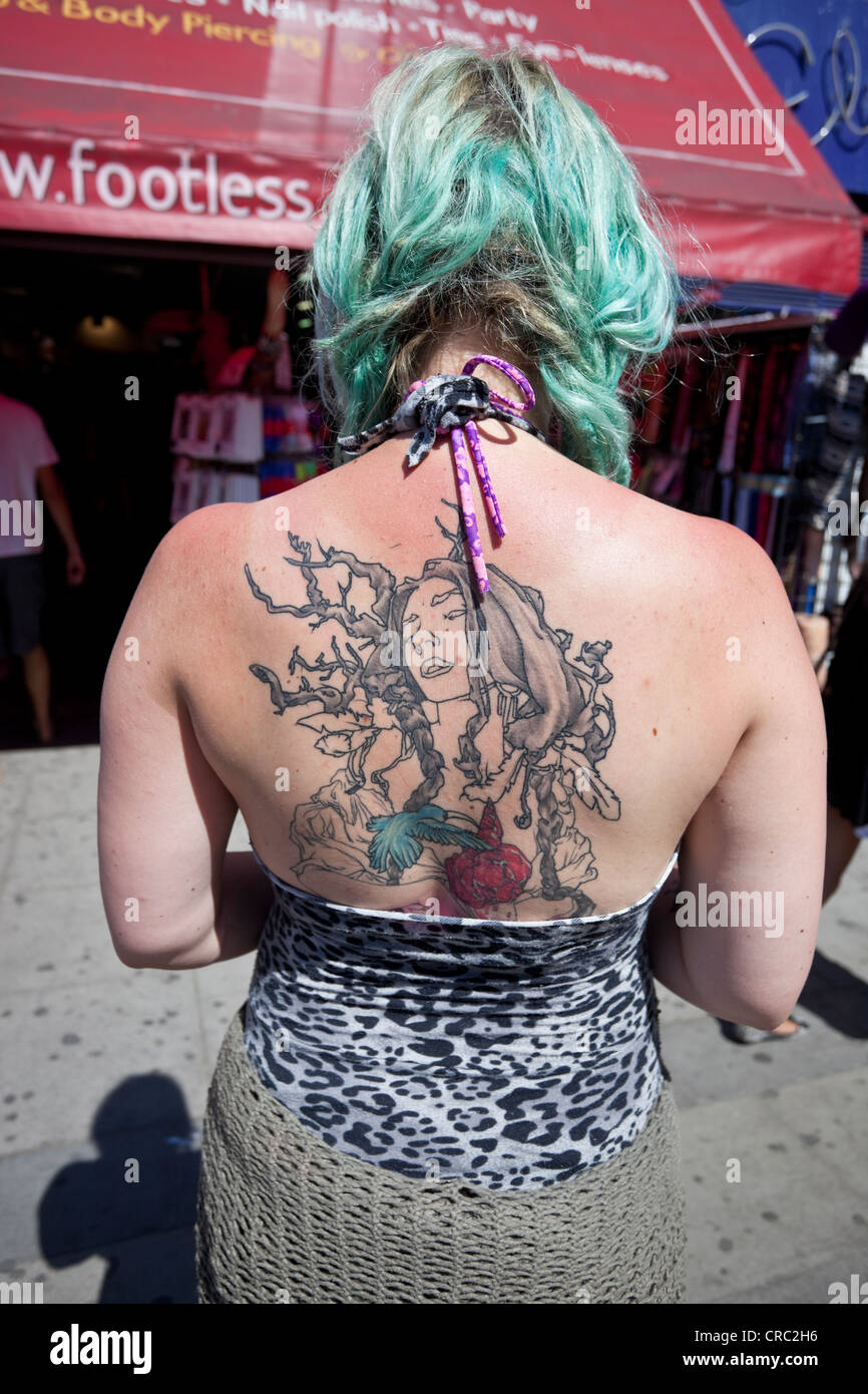 Vista angolare posteriore di una donna alla moda con un grande tatuaggio che copre la schiena, Camden Town, Londra, Inghilterra, Regno Unito. Foto Stock