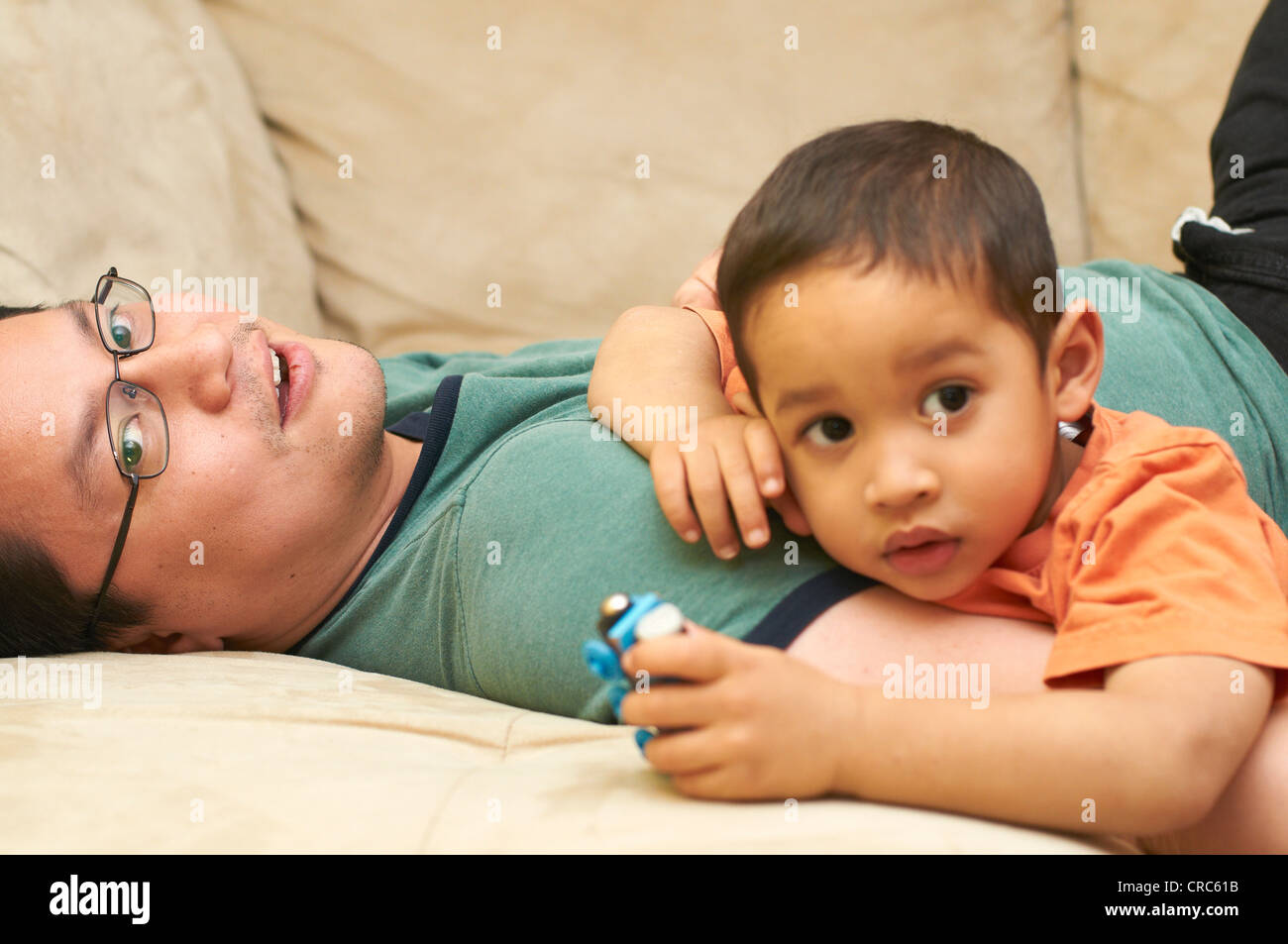 Padre e figlio rilassante sul divano Foto Stock