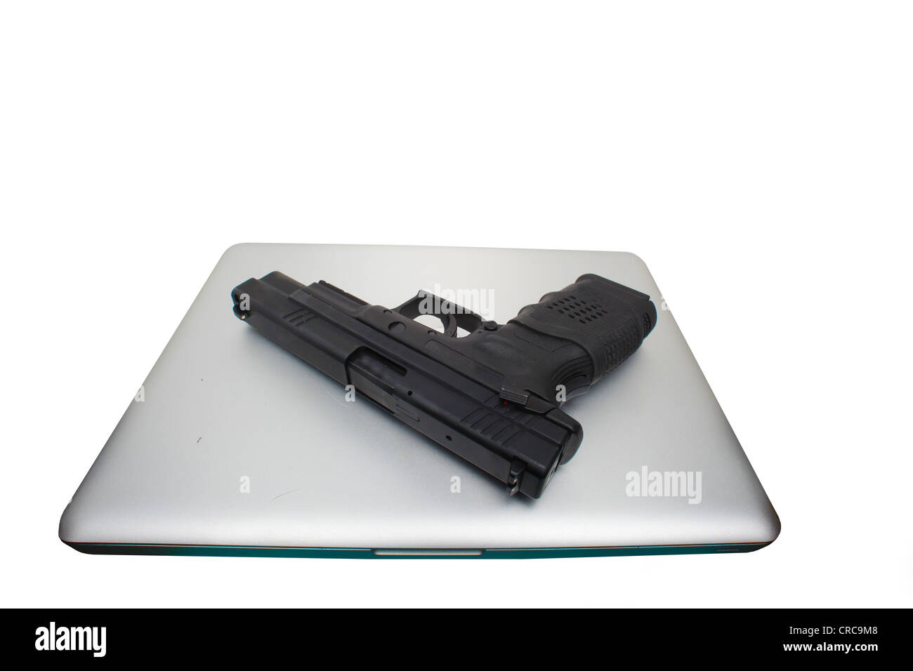 Pistola automatica prevista sulla cima di un alluminio rivestita di computer notebook Foto Stock