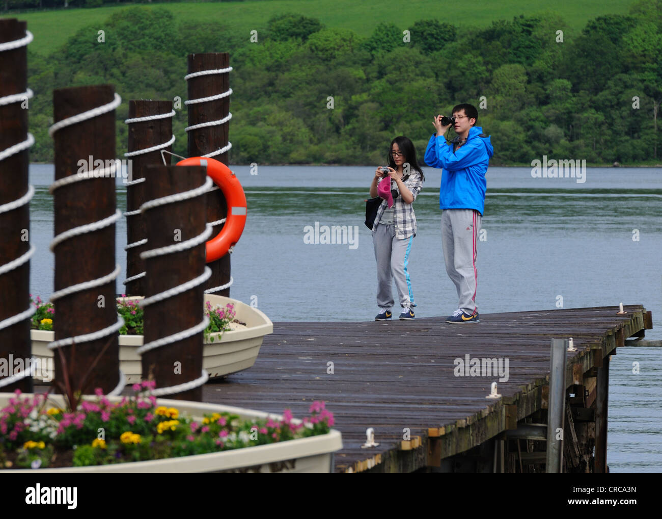 I turisti di scattare una foto sul Duck Bay pier sul Loch Lomond Foto Stock