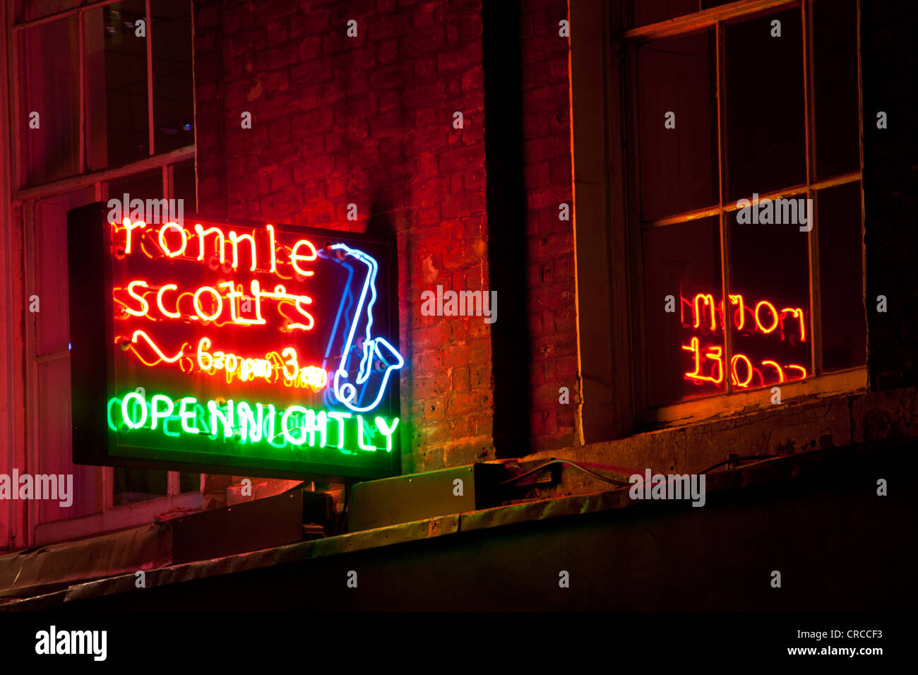 Ronnie Scott live jazz club / venue insegna al neon riflessa nella finestra al piano di sopra Frith Street Soho Londra Inghilterra REGNO UNITO Foto Stock
