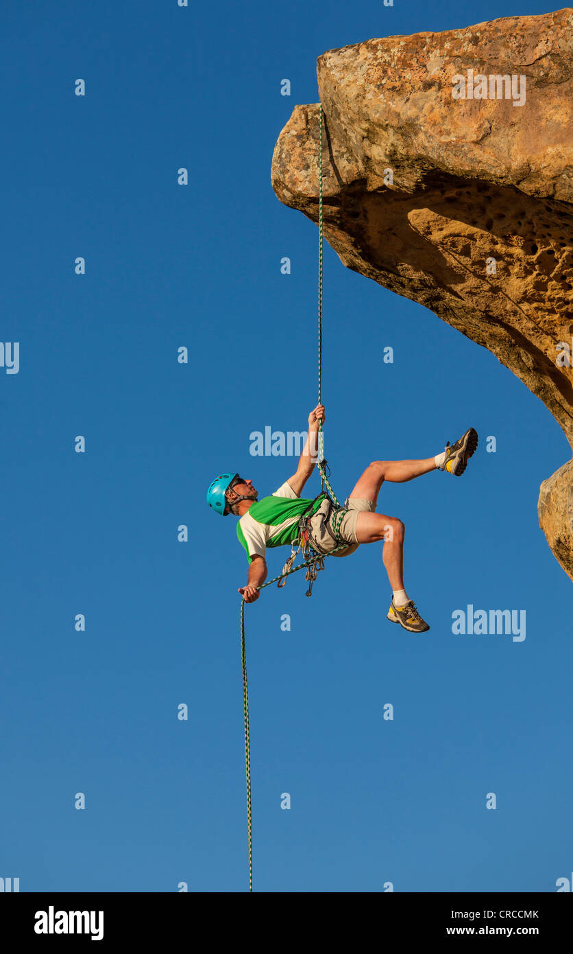 Scalatore rappels libero dal vertice dopo una impegnativa salita. Foto Stock