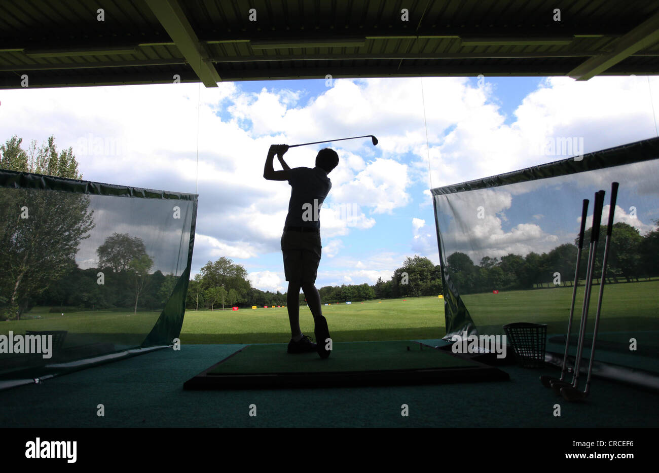 Un golfista praticando nella gamma di guida.. Foto Stock