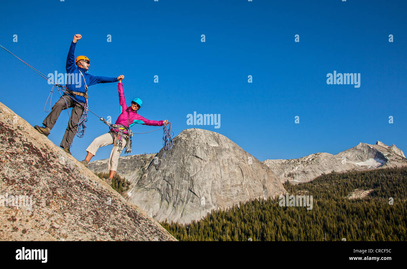 Il team di arrampicata sul vertice celebrare dopo una impegnativa salita. Foto Stock