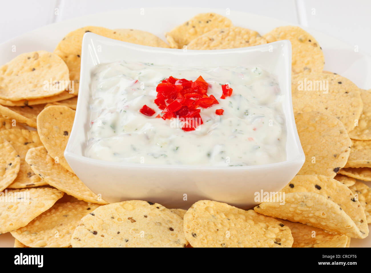 Popolari accompagnamento a piatti Indiani, raita di cetriolo e rabboccato con peperoncino, circondato da mini poppadums per immersione. Foto Stock