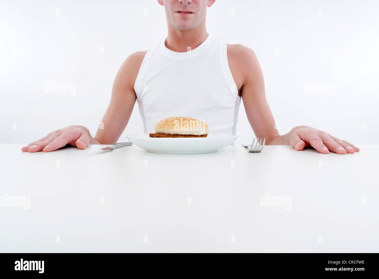 Giovane con hamburger in corrispondenza della piastra Foto Stock