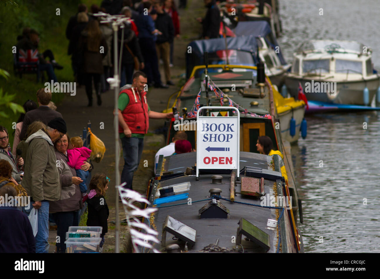 Un canal boat essendo utilizzato come un book shop in vista delle barche strette e molte persone a Leicester Riverside Festival Foto Stock