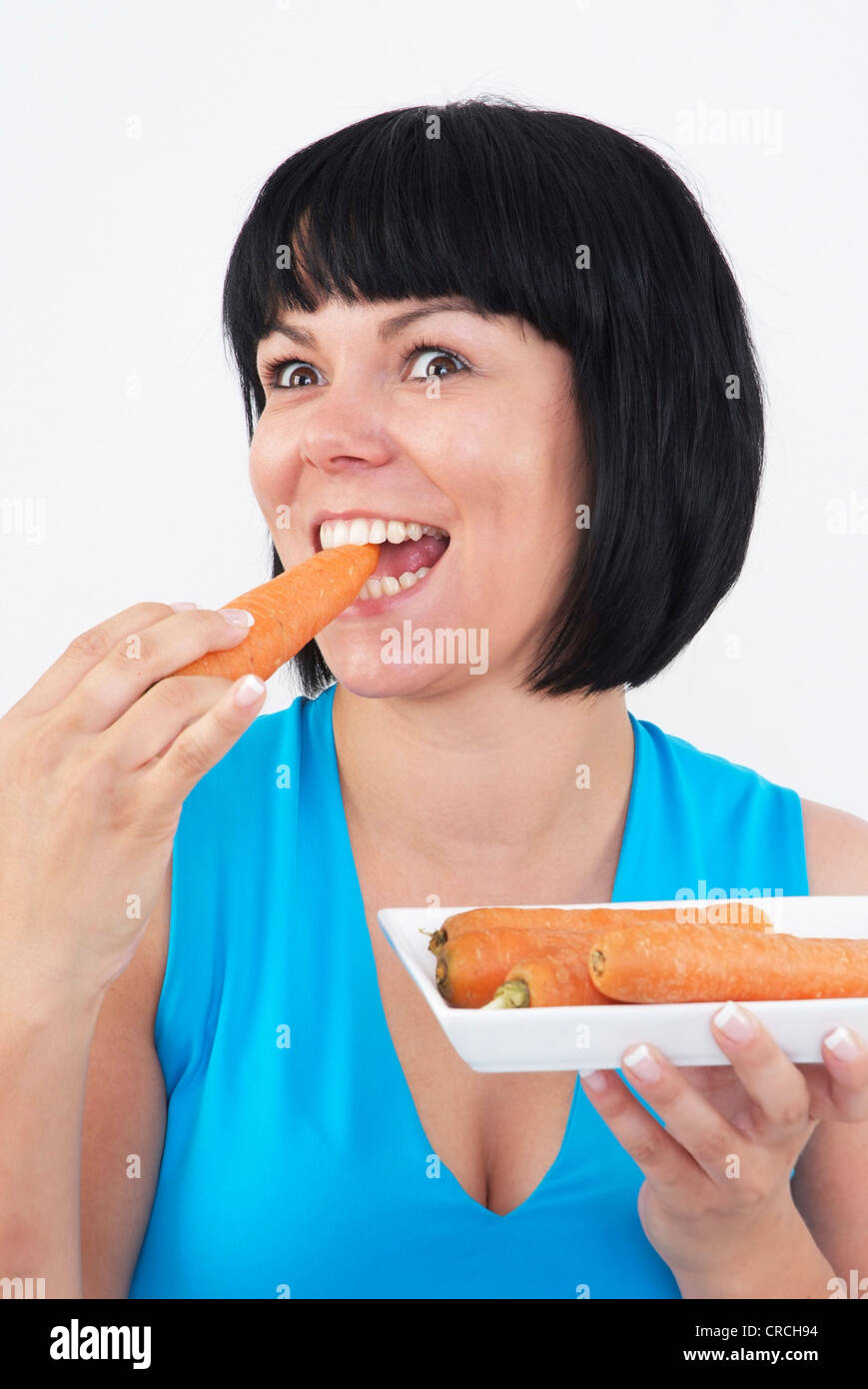 Donna mangia una carota Foto Stock