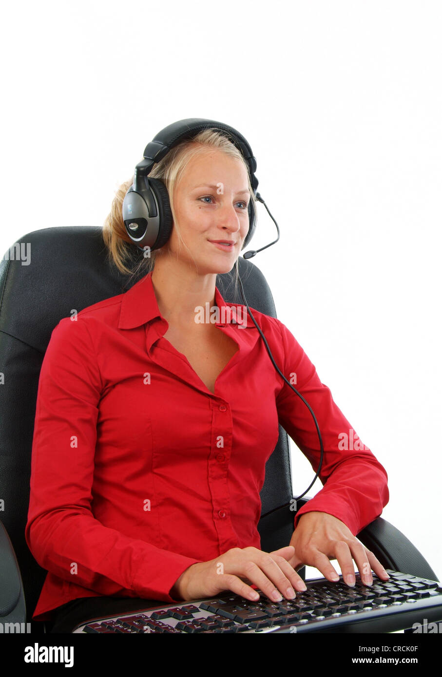 Giovane donna bionda con cuffie e tastiera sul giro Foto Stock