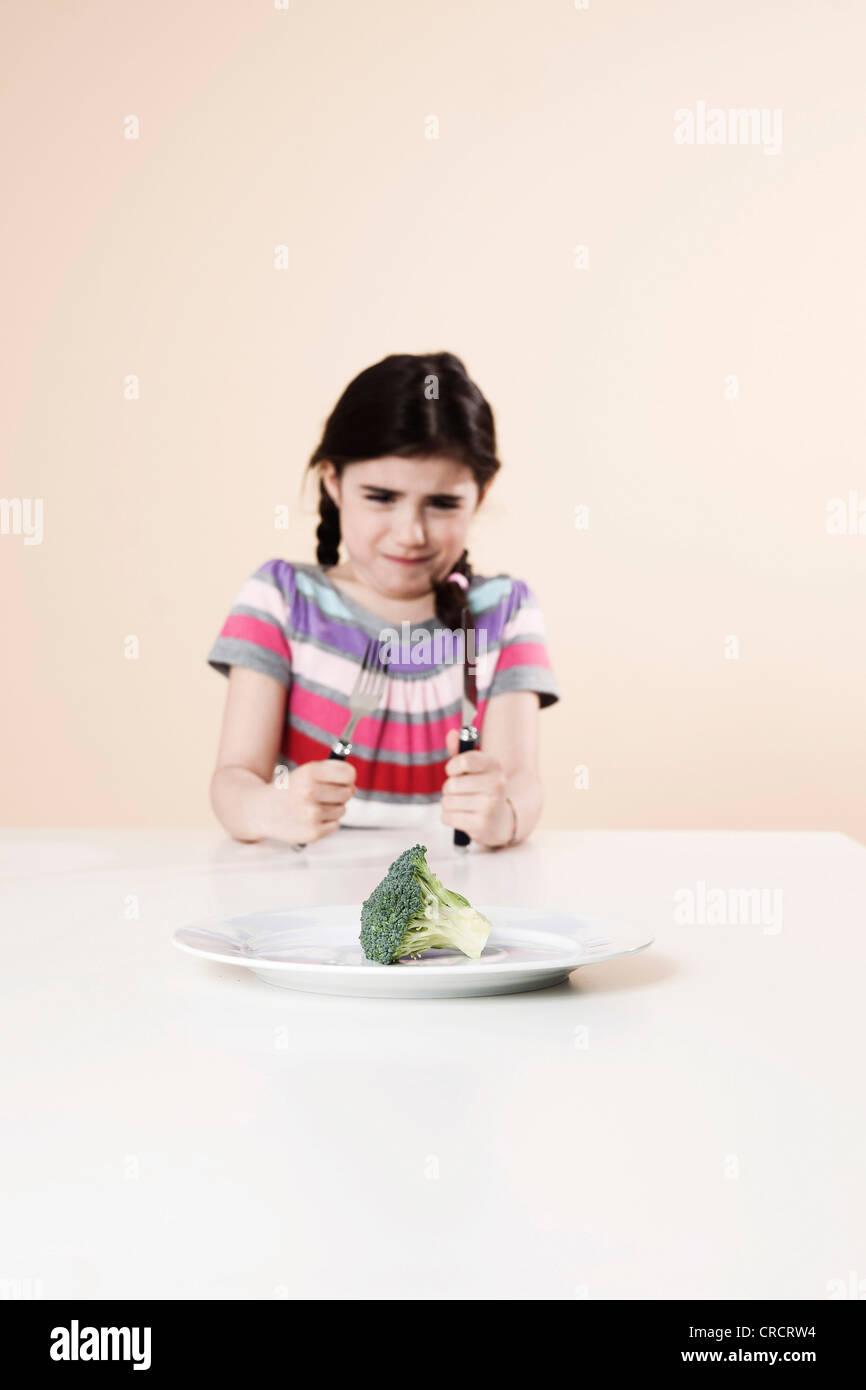 Ragazza che rifiuta di mangiare i broccoli Foto Stock