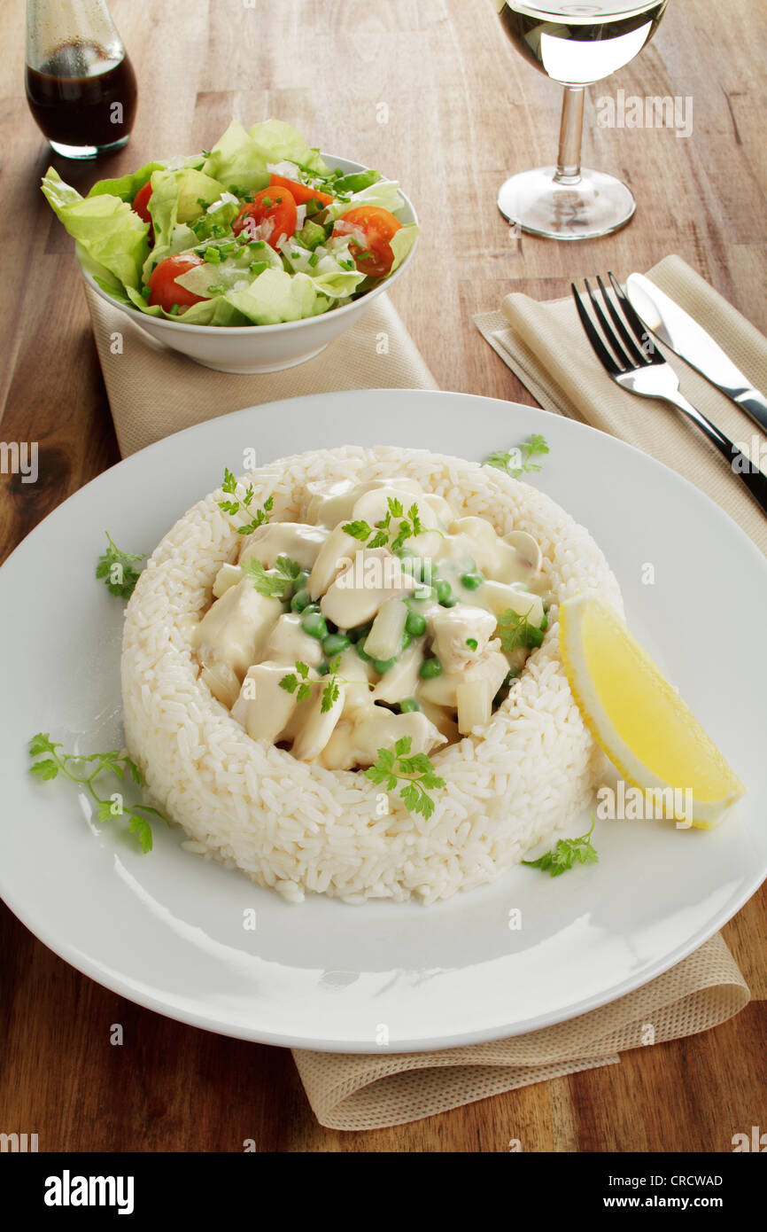 Pollo in fricassea con asparagi, i piselli e i funghi in un anello di riso,  insalata di salsa Worcestershire, vino bianco Foto stock - Alamy