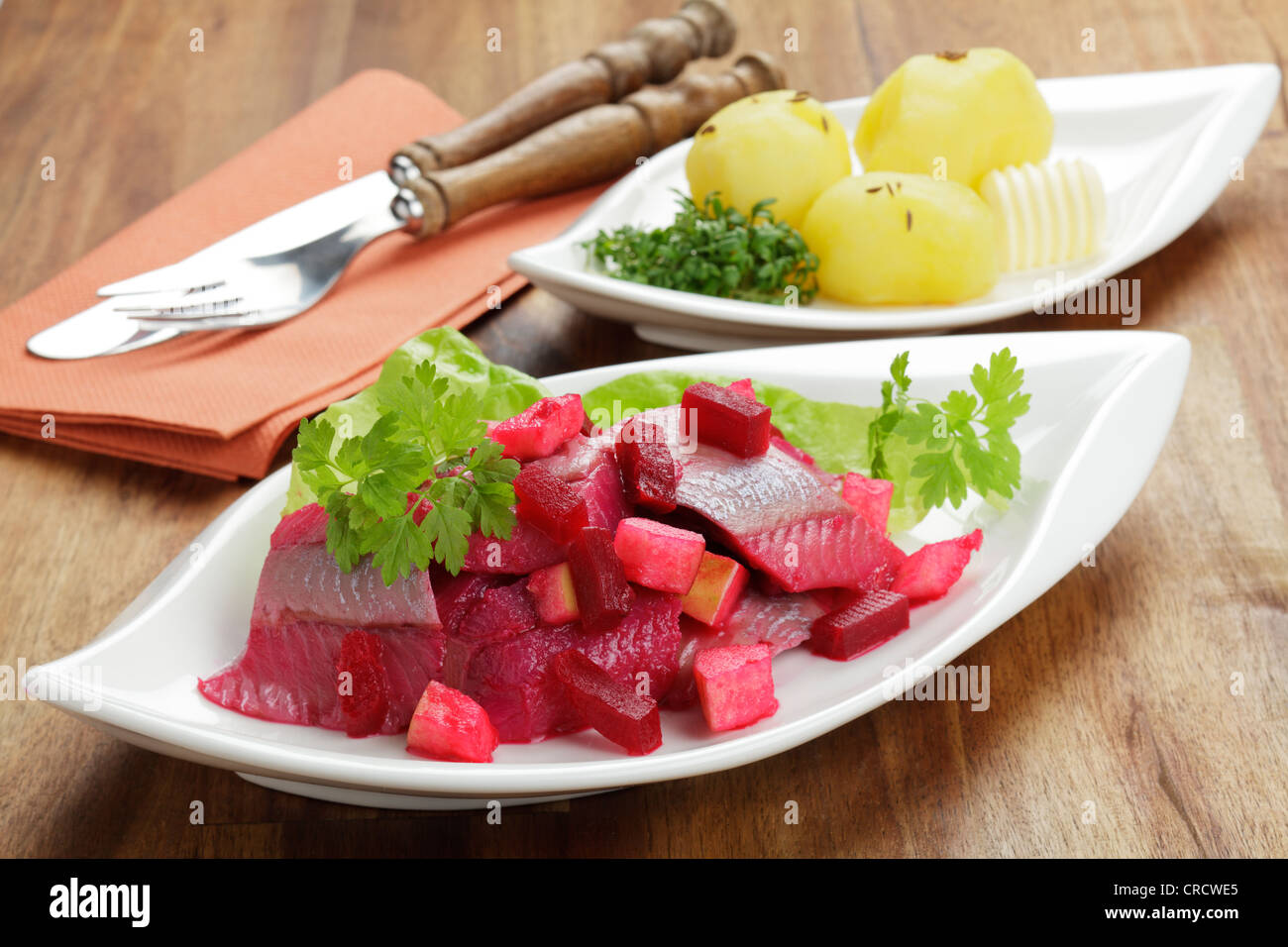 Insalata di aringa soused con barbabietola e pezzi di apple, servito con patate bollite Foto Stock