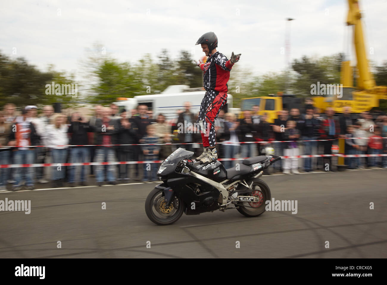 Motociclo Stuntman Mike Auffenberg stando in piedi sul sedile della sua moto, Coblenza, Renania-Palatinato, Germania, Europa Foto Stock