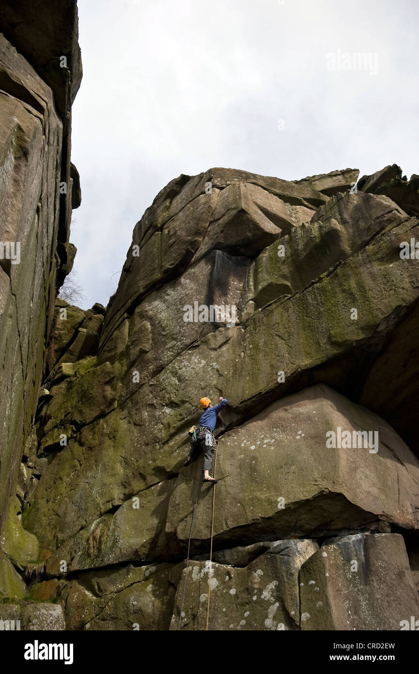 Rocciatore sul crack a Cratcliffe rocce del Peak District, Derbyshire, Regno Unito Foto Stock