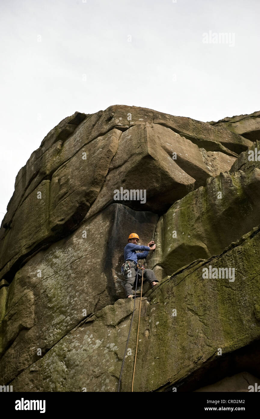 Rocciatore sul crack a Cratcliffe rocce del Peak District, Derbyshire, Regno Unito Foto Stock