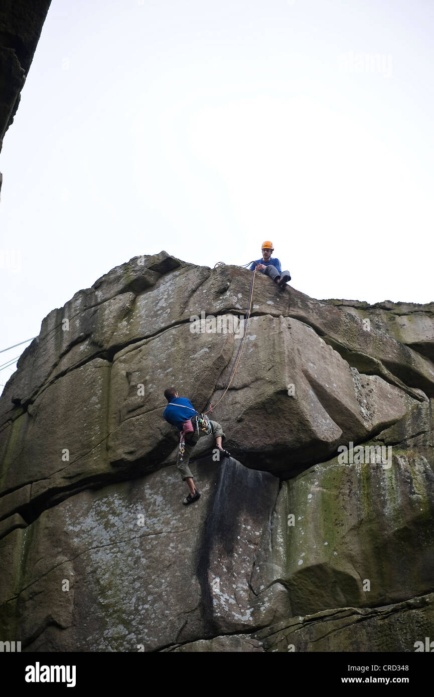 Rocciatore sul crack a Cratcliffe rocce del Peak District, Derbyshire, Regno Unito Foto Stock