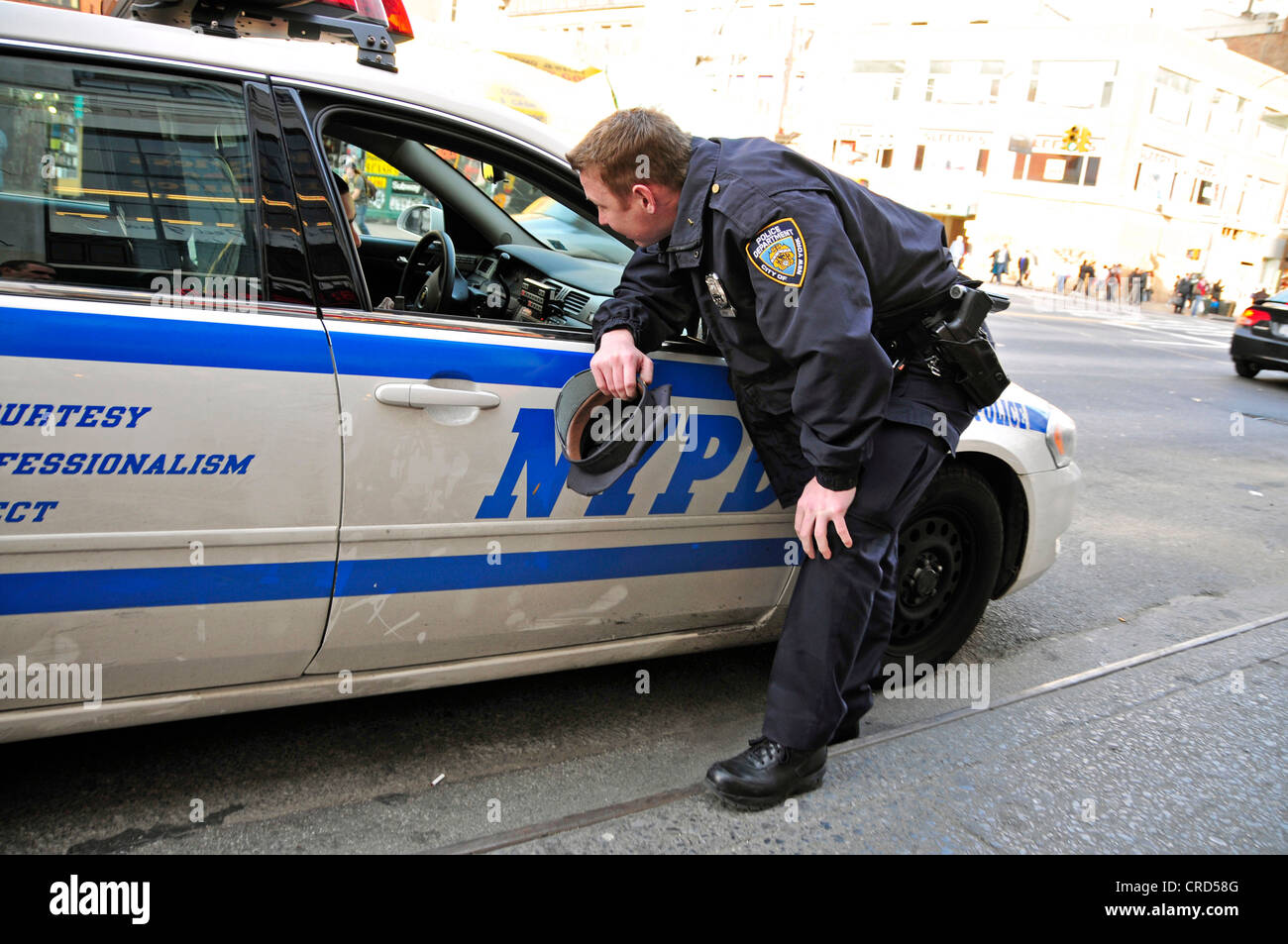 Funzionario di polizia del NYPD parlando con alcuni altri uomini della polizia in una macchina della polizia, USA, New York City, Manhattan Foto Stock