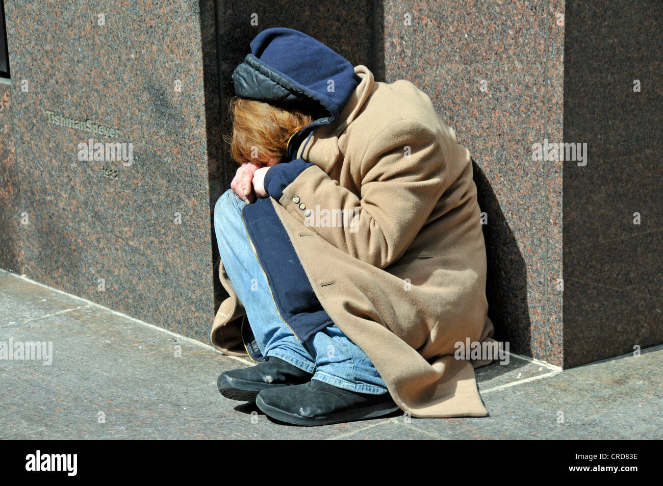 Junkie seduto per terra davanti a un edificio di uffici, USA, New York City, Manhattan Foto Stock