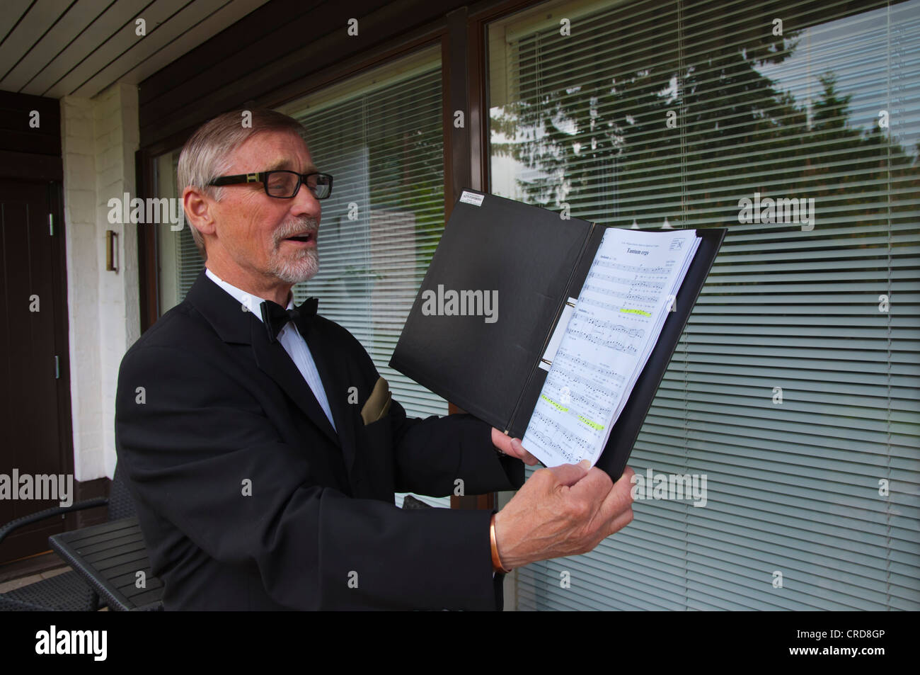 L'uomo nei suoi primi anni settanta la pratica per coro cantando con note Finlandia Europa Foto Stock