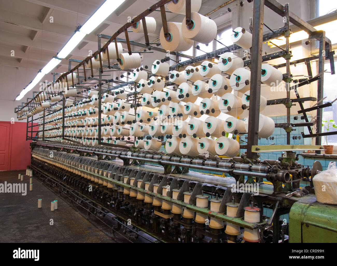 Filato di cotone su grandi steli e fabbrica tessile attrezzature in officina Foto Stock