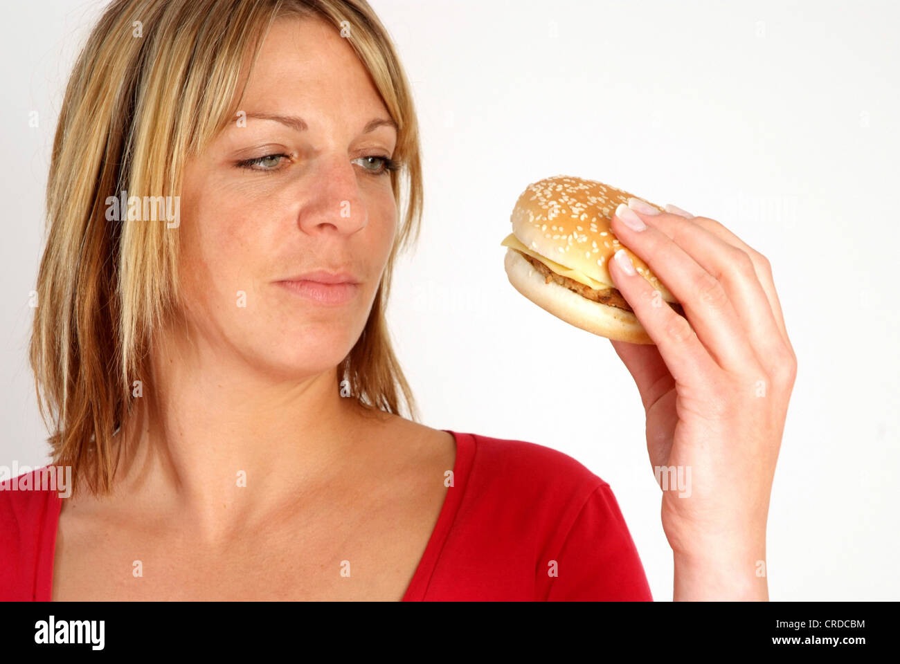 Biondo donna con burger in mano Foto Stock