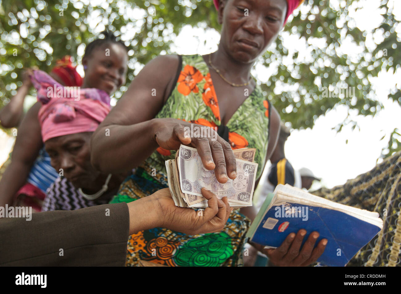 Una donna riceve il denaro durante una cassa sociale programma di trasferimento la distribuzione nel villaggio di Julijuah, Contea Bomi, Liberia Foto Stock