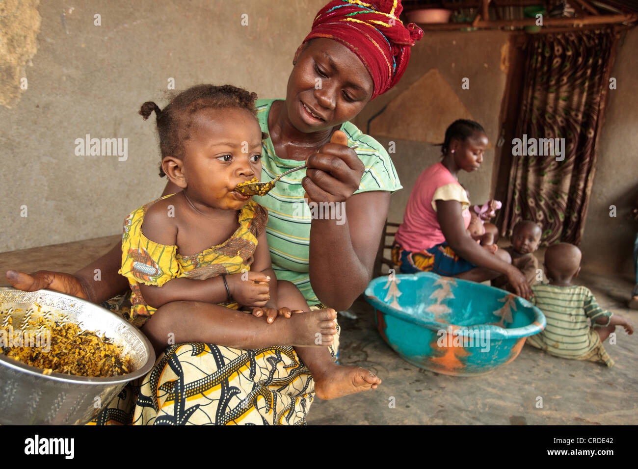 Jenneh Johnson, 31, alimenta la figlia Jusu, 2, a casa nel villaggio di Julijuah, Contea Bomi, Liberia Foto Stock