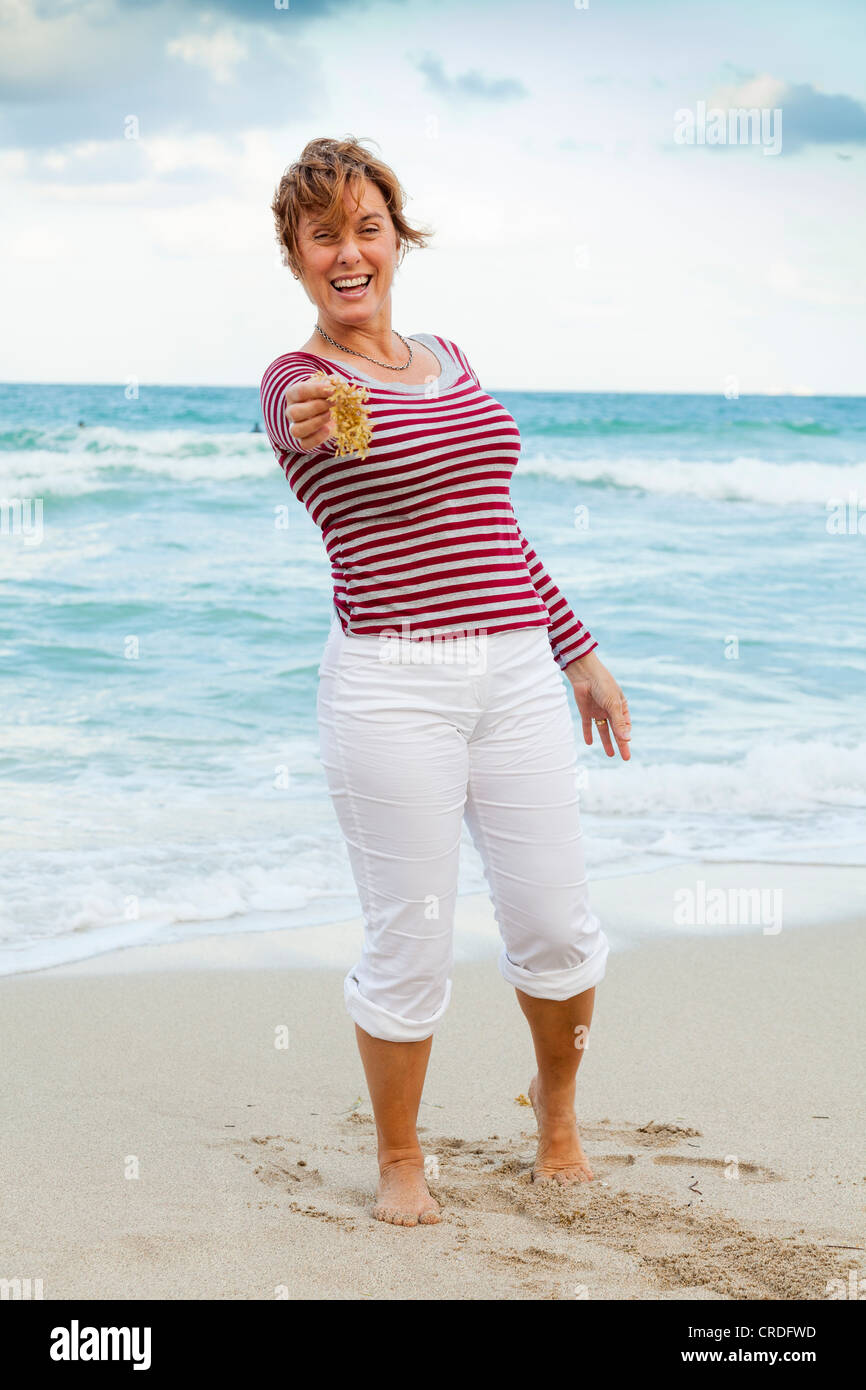 Donna in spiaggia, sorridente, ritratto Foto Stock